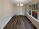 Bright dining room featuring a modern chandelier, dark floors, and ample natural light from a large window at 521 Country Lake Dr, Mcdonough, GA 30252