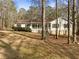 Ranch home with stone accents and a covered front porch in a wooded setting at 521 Country Lake Dr, Mcdonough, GA 30252