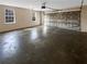 Spacious garage with a roll-up door, featuring two windows and a concrete floor at 521 Country Lake Dr, Mcdonough, GA 30252