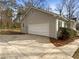 Spacious garage with extra driveway parking, surrounded by a well-kept yard and mature trees at 521 Country Lake Dr, Mcdonough, GA 30252