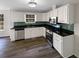 Charming kitchen featuring white cabinetry, stainless appliances, and dark countertops with backsplash at 521 Country Lake Dr, Mcdonough, GA 30252