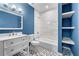 Stylish bathroom with blue walls, hexagonal floors and tub shower with white marble tile at 667 Creswell Park, Smyrna, GA 30082