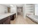 Bathroom featuring a soaking tub, stand-up shower, granite countertops, and wood cabinets at 667 Creswell Park, Smyrna, GA 30082