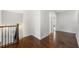 Hallway with wood flooring, base trim, railing with black iron balusters, and a door to another room at 667 Creswell Park, Smyrna, GA 30082