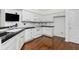 Well-lit kitchen featuring white cabinets, black countertops, and stainless steel appliances at 2406 Village Ln, Roswell, GA 30075