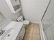 Cozy bathroom featuring a tiled floor, shower and sink with white cabinets and a matching medicine cabinet at 212 Riverstone Commons Cir, Canton, GA 30114