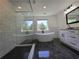 Modern bathroom with glass shower, soaking tub, and marble tile at 2173 Montrose Sw Ave, Atlanta, GA 30311
