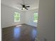 Light-filled bedroom with dark hardwood floors, a ceiling fan, and picturesque views from two windows at 2173 Montrose Sw Ave, Atlanta, GA 30311