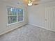 Cozy bedroom boasts soft carpeting, a ceiling fan with lighting, and a large window, all painted in neutral tones at 483 Fairlane Nw Cir, Atlanta, GA 30331