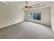 Spacious carpeted bedroom featuring a tray ceiling, ceiling fan, and a large window at 4905 Ascot Nw Blf, Acworth, GA 30102