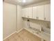 Practical laundry room with tiled flooring, utility sink and storage cabinets at 4905 Ascot Nw Blf, Acworth, GA 30102