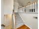 Bright foyer showcasing carpeted stairs with white railing and hardwood flooring at 4905 Ascot Nw Blf, Acworth, GA 30102