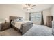 A neutral bedroom is furnished with gray wood furniture, large window and plush gray carpet at 4929 Dufour Dr, Lilburn, GA 30047