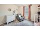 Bright Bedroom featuring rocking chair, white dresser, and window with orange curtains at 4929 Dufour Dr, Lilburn, GA 30047