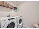 Functional laundry room featuring a Whirlpool washer and dryer and shelf at 4929 Dufour Dr, Lilburn, GA 30047