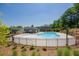 Community pool with a lounge area, surrounded by a black metal fence and landscaping at 4929 Dufour Dr, Lilburn, GA 30047