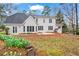 Backyard of home with stucco exterior, lots of windows and doors, flower beds, and foliage in the yard at 10625 Haynes Forest Dr, Alpharetta, GA 30022