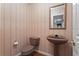 Cozy powder room featuring a pedestal sink, toilet, and classic wallpaper at 10625 Haynes Forest Dr, Alpharetta, GA 30022