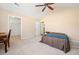 A bedroom with tan walls, ceiling fan, a small bed and a view into the closet and bathroom at 2160 Carefree Cir # 9, Marietta, GA 30062