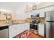 Well-appointed kitchen boasts stainless steel appliances, granite countertops, and white cabinets at 2160 Carefree Cir # 9, Marietta, GA 30062