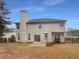 Back exterior view of the house featuring a patio and a large backyard with mature trees at 2208 Howell Farms Nw Pt, Acworth, GA 30101