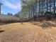 Backyard featuring a sloped lot, mature trees, and privacy fence at 2208 Howell Farms Nw Pt, Acworth, GA 30101