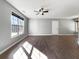 Bright living room with wood floors, large window, ceiling fan, and neutral paint at 338 Thorn Thicket Dr, Rockmart, GA 30153