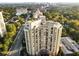 Stunning aerial view of high-rise condo building surrounded by lush greenery with a city skyline in the distance at 2626 Peachtree Nw Rd # 206, Atlanta, GA 30305