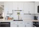 Close up of a modern kitchen with white cabinets, quartz countertop, brass hardware, and tile backsplash at 325 E Paces Ferry Ne Rd # 2005, Atlanta, GA 30305