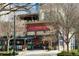 Exterior shot of an inviting restaurant with a red facade, outdoor seating, and a charming architectural design at 325 E Paces Ferry Ne Rd # 2005, Atlanta, GA 30305