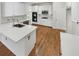 Stylish kitchen featuring white cabinetry, quartz countertops, stainless steel appliances, and hardwood floors at 5025 Skipping Stone Ct, Cumming, GA 30028