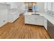 A kitchen with white countertops, stainless steel appliances, and a large island flows to the living room at 5025 Skipping Stone Ct, Cumming, GA 30028