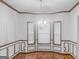 Elegant dining room featuring a chandelier, three windows, and classic wall paneling at 5589 Dendy Trace, Fairburn, GA 30213