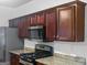 Kitchen featuring granite countertops, stainless steel appliances, and dark wood cabinets at 5589 Dendy Trace, Fairburn, GA 30213