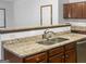 Kitchen showcasing granite countertops, stainless steel sink, and brown cabinets at 5589 Dendy Trace, Fairburn, GA 30213