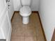 Tiled bathroom floor with a toilet in a small space, surrounded by white walls and dark trim at 5589 Dendy Trace, Fairburn, GA 30213