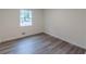 Bright bedroom with wood-look flooring and a window offering natural light at 8483 Magnolia Dr, Jonesboro, GA 30238