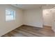 Bedroom featuring modern wood-look floors, white walls, and a window at 8483 Magnolia Dr, Jonesboro, GA 30238