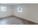 Bedroom featuring modern wood-look floors, white walls, and natural light from windows at 8483 Magnolia Dr, Jonesboro, GA 30238