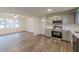 Open concept living room and kitchen area with stainless steel appliances and hardwood floors at 8483 Magnolia Dr, Jonesboro, GA 30238