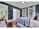 Charming bedroom features navy walls, wood floors, ensuite bathroom, and natural light at 115 17Th Ne St, Atlanta, GA 30309