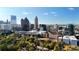 Panoramic view of the city skyline with modern skyscrapers and lush green trees under a bright blue sky at 115 17Th Ne St, Atlanta, GA 30309