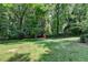 Expansive backyard with mature trees offering plenty of shade and a red shed for extra storage at 4253 Smithsonia Dr, Tucker, GA 30084