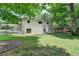 Spacious backyard featuring green grass and mature trees and a white home at 4253 Smithsonia Dr, Tucker, GA 30084