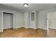Bedroom with hardwood floors, closet, a built-in display case, and white trim, offering character and storage at 4253 Smithsonia Dr, Tucker, GA 30084