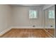 Bedroom featuring hardwood floors, a mirrored closet, and natural light from the windows at 4253 Smithsonia Dr, Tucker, GA 30084
