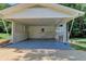 Attached carport with painted floor, brick foundation, and convenient access door to the home's interior at 4253 Smithsonia Dr, Tucker, GA 30084