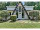 A-frame home with an inviting front entrance and glass inserts, complemented by lush landscaping at 4253 Smithsonia Dr, Tucker, GA 30084