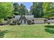 A-frame home featuring a well-manicured lawn and mature trees, offering privacy and curb appeal at 4253 Smithsonia Dr, Tucker, GA 30084