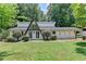 A-frame home with unique architectural design, surrounded by a green lawn and mature trees at 4253 Smithsonia Dr, Tucker, GA 30084
